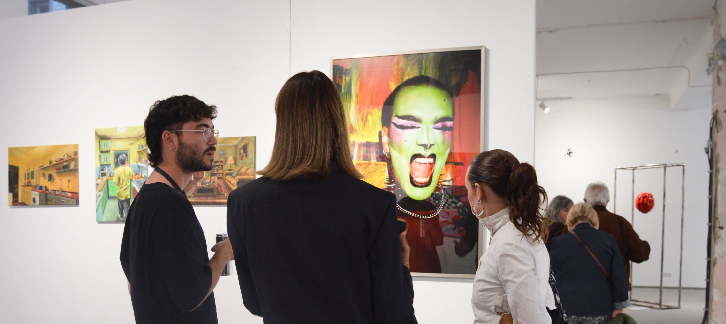 People visiting notagallery with colorful paintings on the wall.